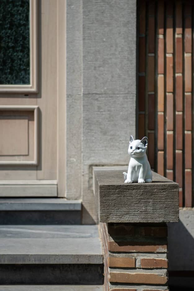 statue jardin style chat moderne Medium blanc et oreilles argentées devant porte